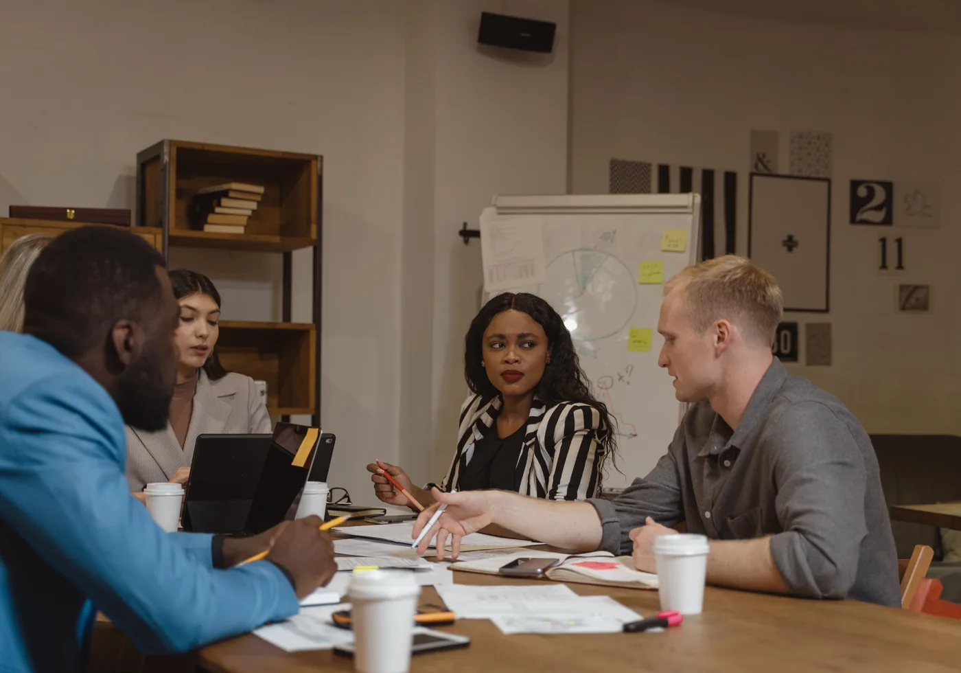 Business professionals reviewing plans and discussing a project around a table