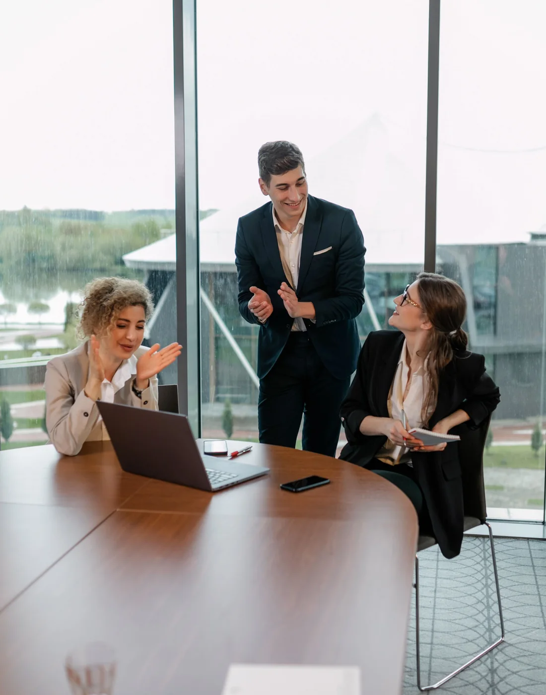 Three professionals having an engaged business conversation in a bright meeting room