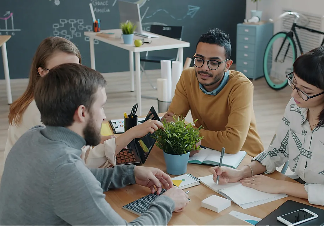 A project team discussing goals and current challenges around a table