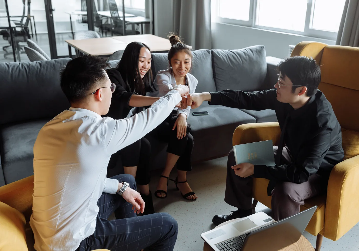 An Asian business team celebrating progress together after a meeting
